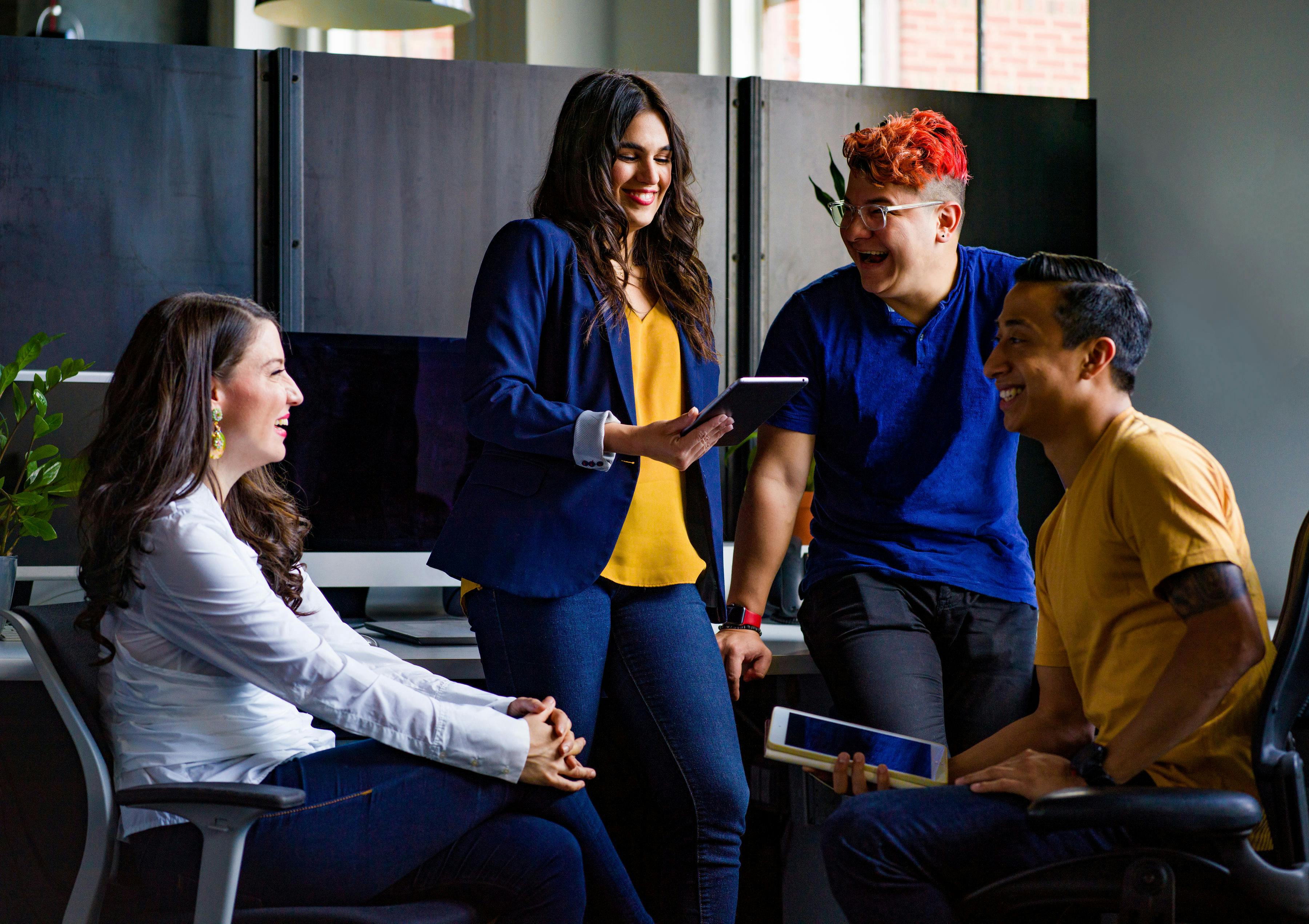 Team of people gathered having a lively discussion in an office.